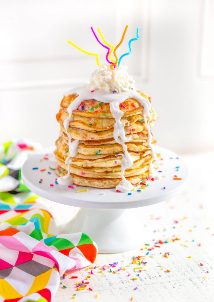 Funfetti Pancakes served on a white cake stand.