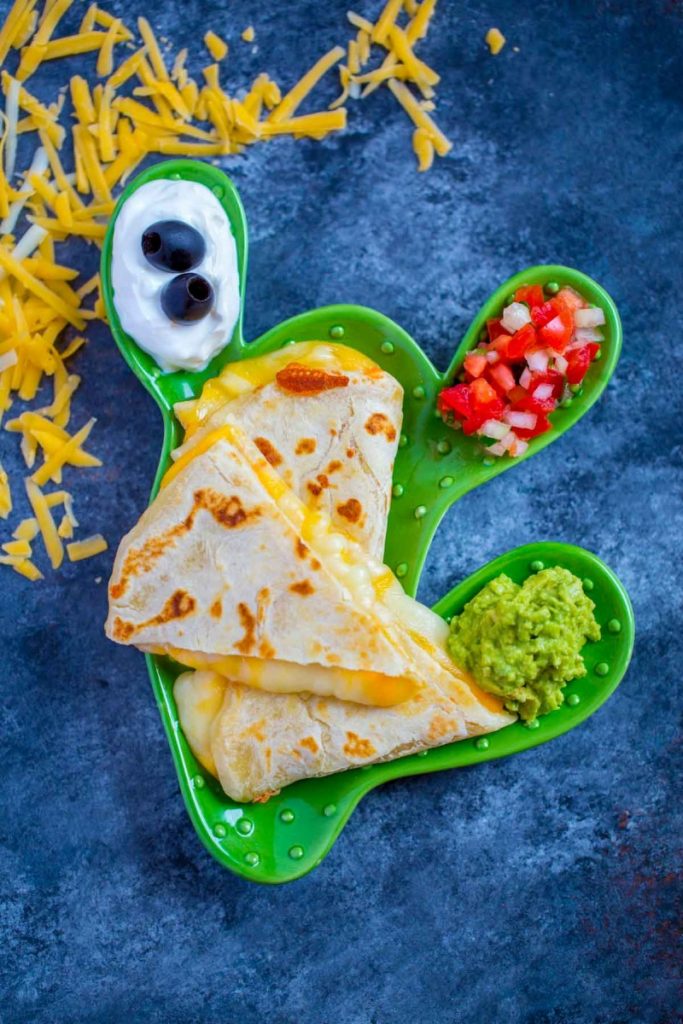 Quesadillas with melted cheese and colorful garnishes.