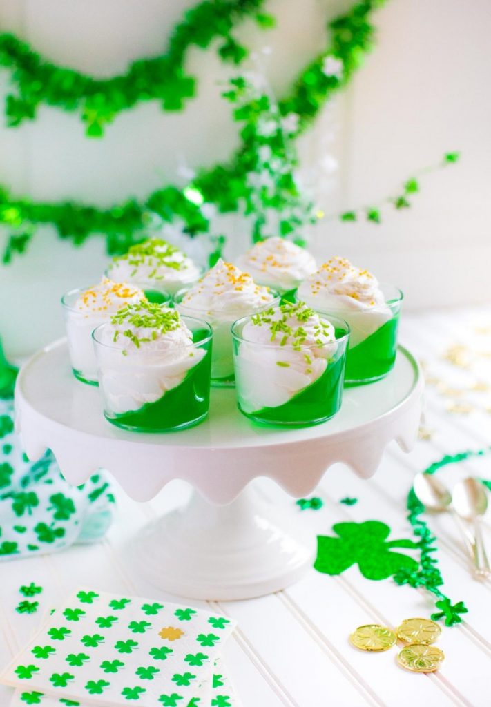 Seven St. Patrick's Day Jello Cups arranged on a dessert stand.