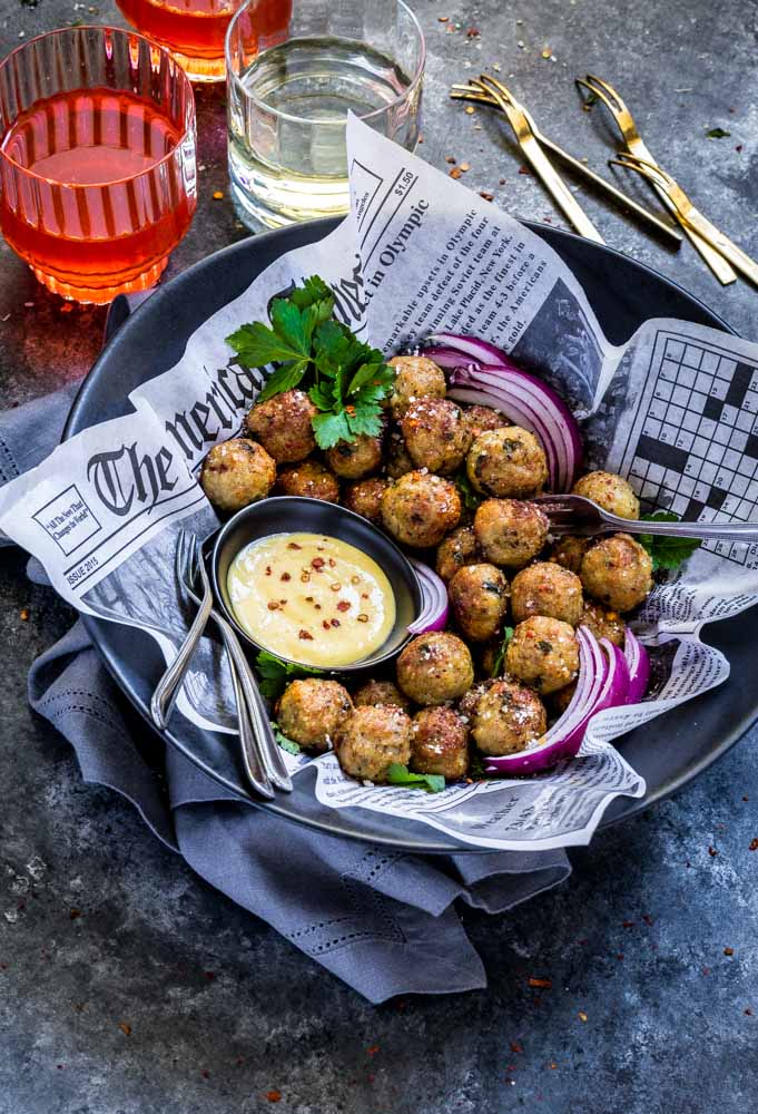 Chicken meatballs in a black serving bowl.