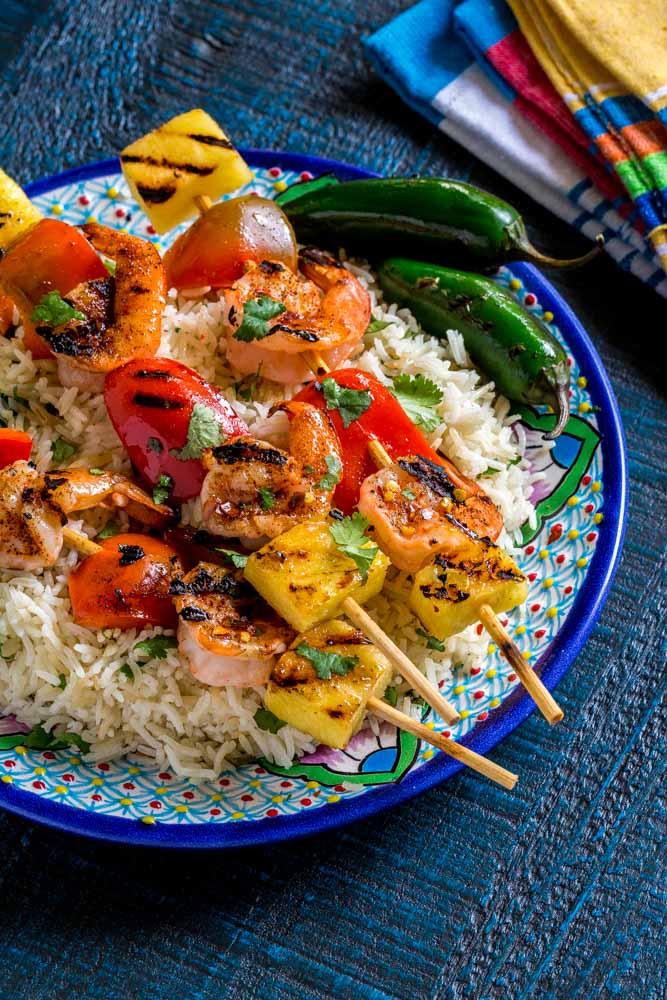 Grilled shrimp skewers on a plate with cilantro lime rice.