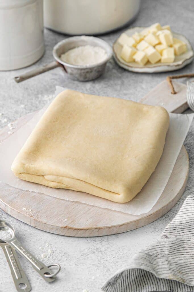 Homemade puff pastry dough on a wooden board for homemade puff pastry sheets.