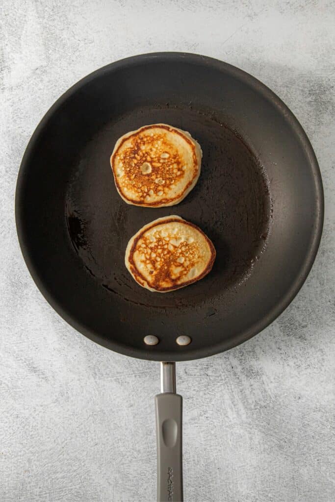 Hotcakes cooking in a skillet.