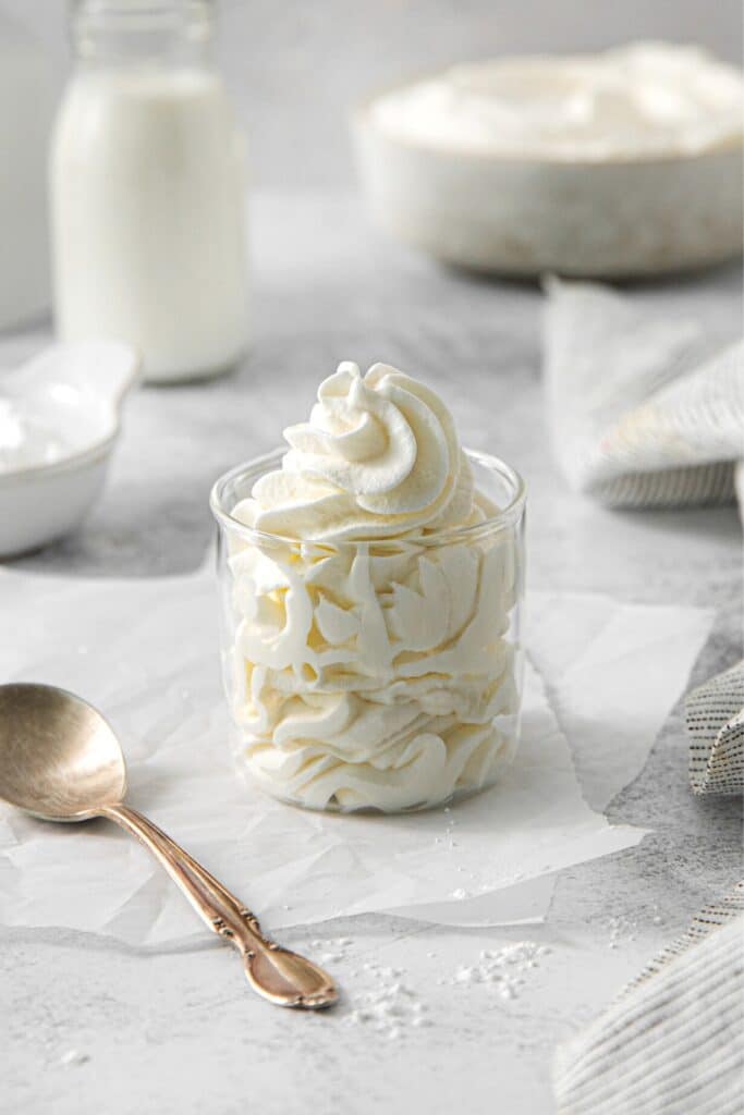 Swirls of vanilla whipped cream piped into a jar.