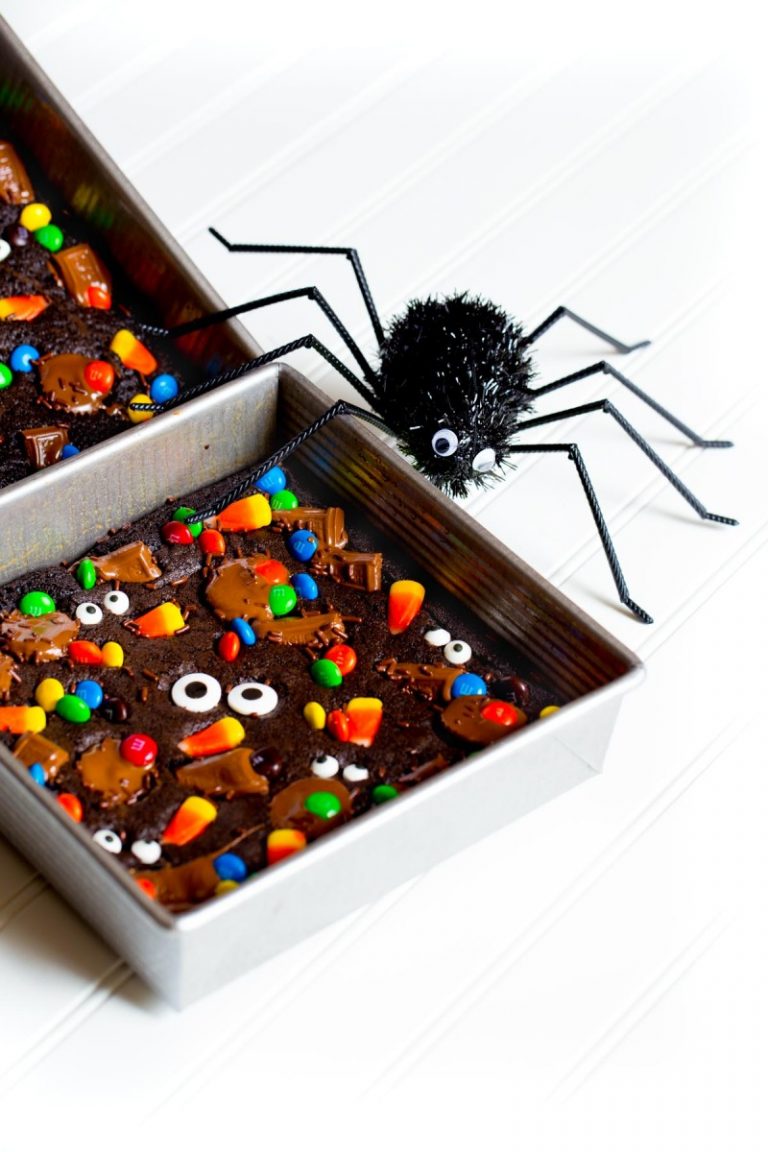 Halloween brownies garnished with a variety of Halloween candies: candy corn, M&Ms, Hershey Bars, candy eyes.