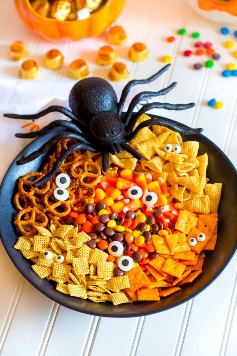 A spooky Halloween snack mix with Chex cereal, pretzels, Bugles, tiny crackers, candies and candy eyes.
