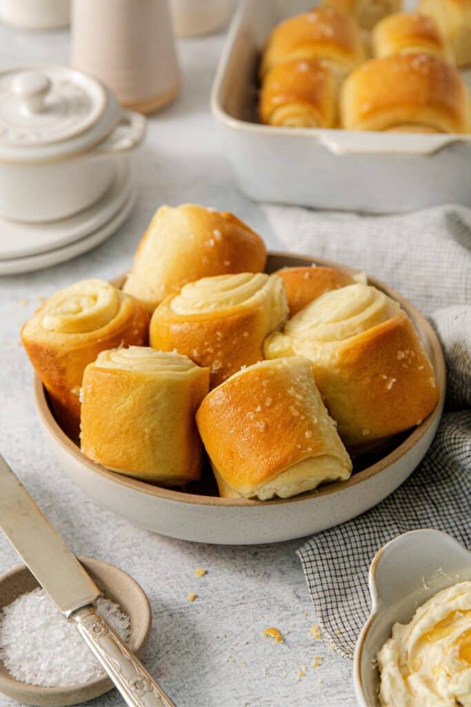 Buttery Parker House rolls in a serving dish.