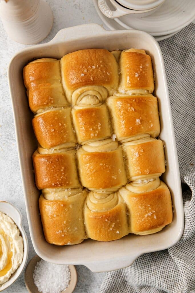 Buttery Parker House rolls brushed with melted butter and sprinkled with flaky salt.