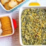 Best Spinach Artichoke Dip served with crackers and chips.