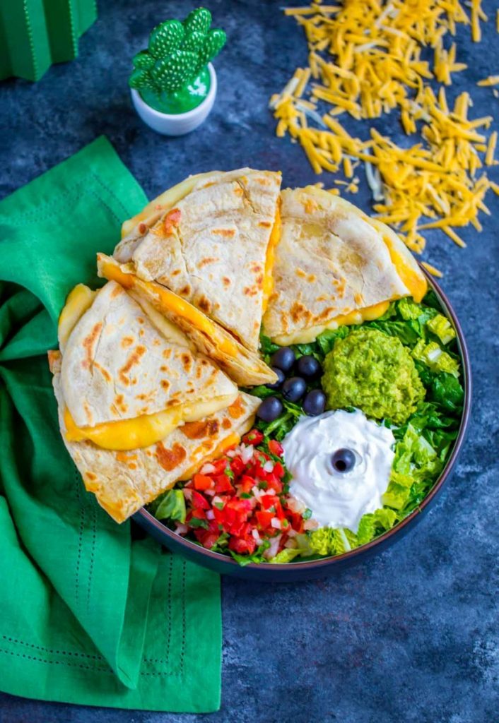 Quesadillas served with colorful Mexican garnishes.