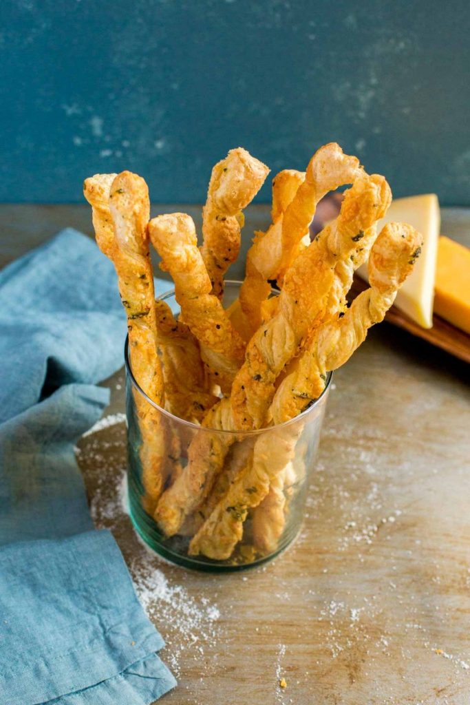 Cheese Straws served in a clear glass dish.