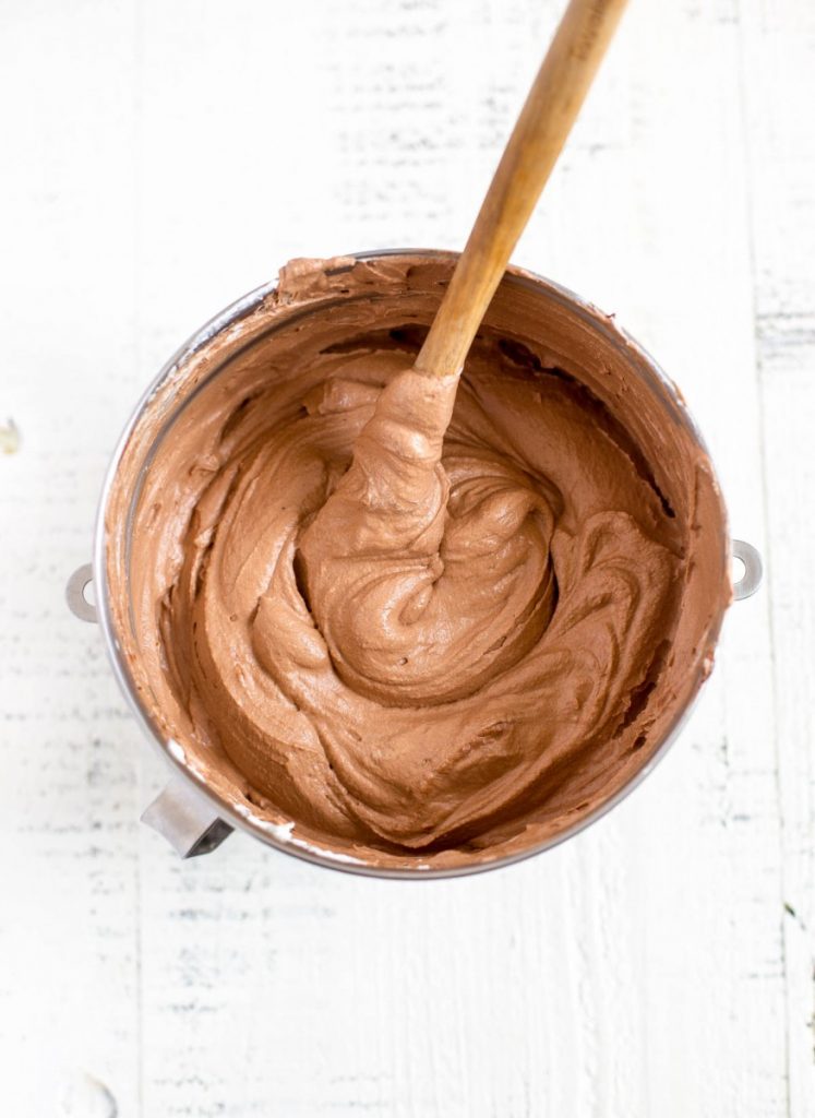 Luscious chocolate mousse in a metal mixing bowl with spatula.