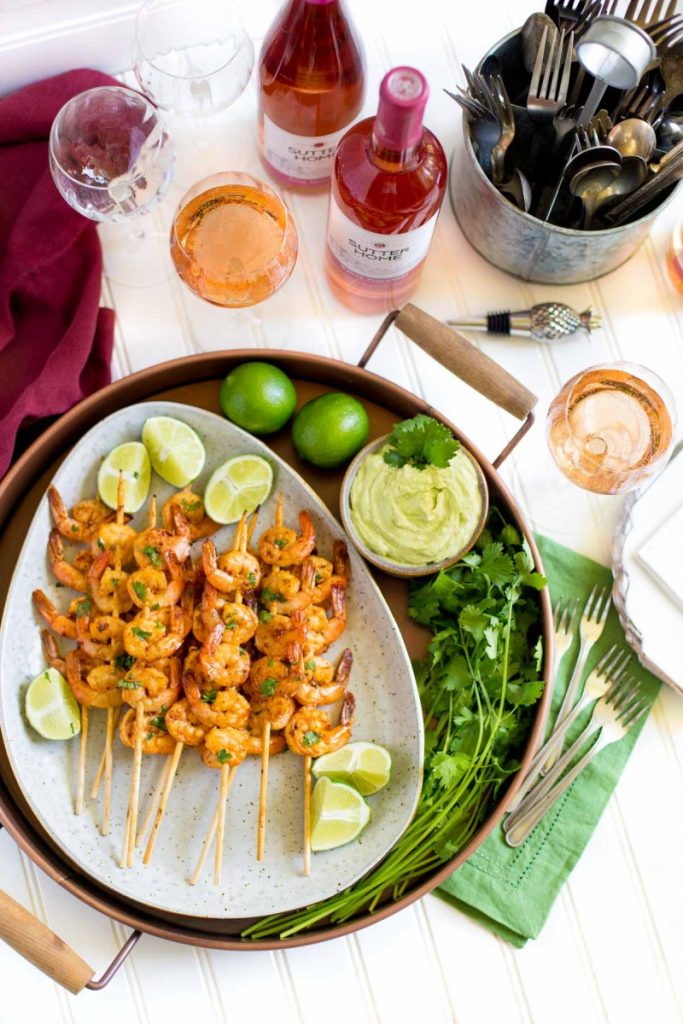 Grilled shrimp on an oval platter with lime slices.