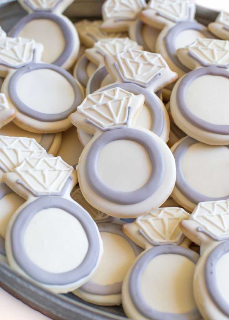 Professional sugar cookies in wedding ring shape, glazed and decorated with icing that hardens.