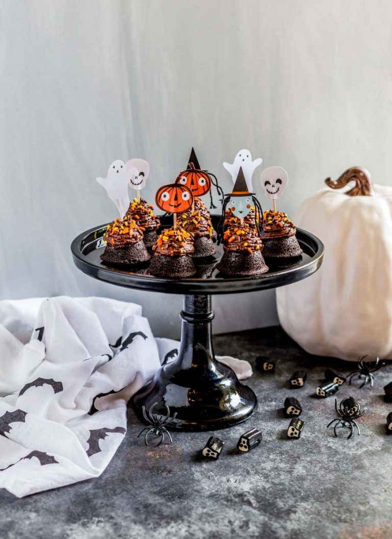 Halloween brownie bites topped with chocolate frosting, candy sprinkles and Halloween cupcake toppers.
