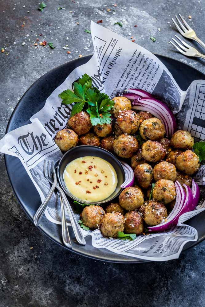 Baked chicken meatballs served in a bowl with honey mustard dipping sauce.