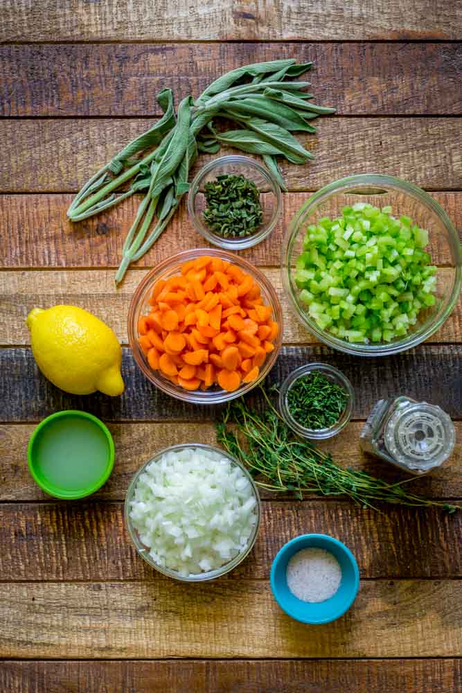 Flat lay image of chopped carrots, onions, celery and herbs for wedding soup.