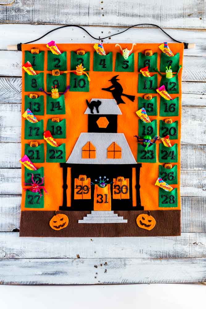 Image showing how to fill Halloween Advent Calendar pockets with candy and tiny toys.