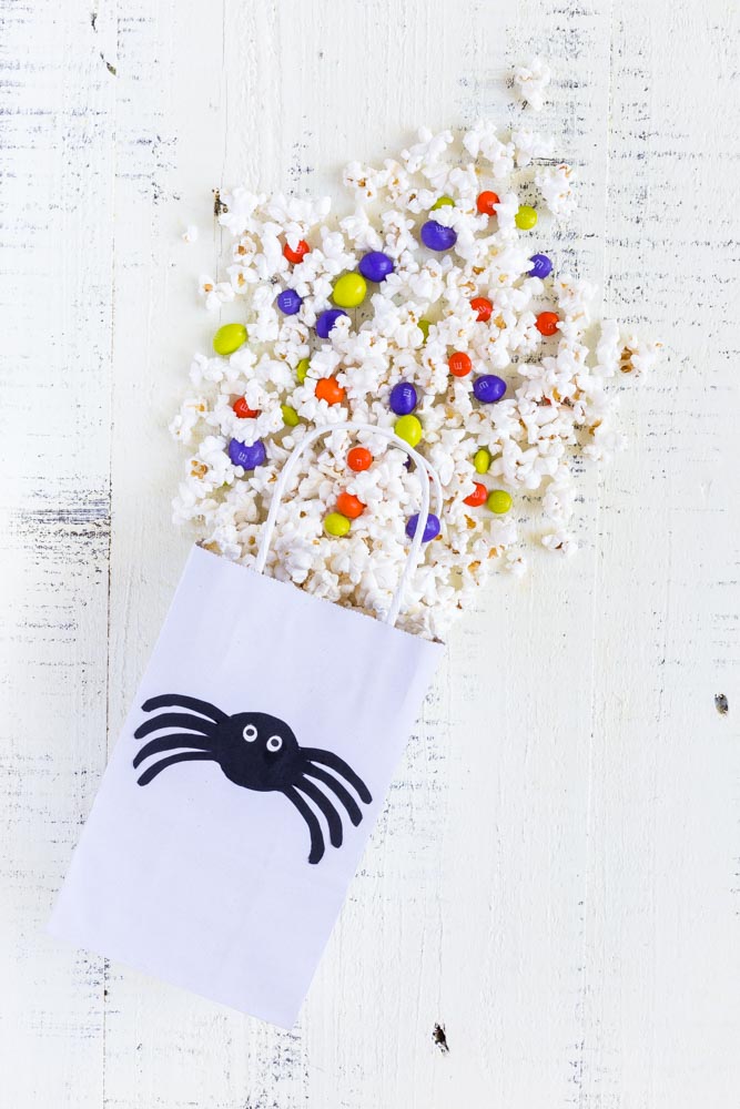 A Movie Night Halloween Popcorn Bag filled with a popcorn candy mix.