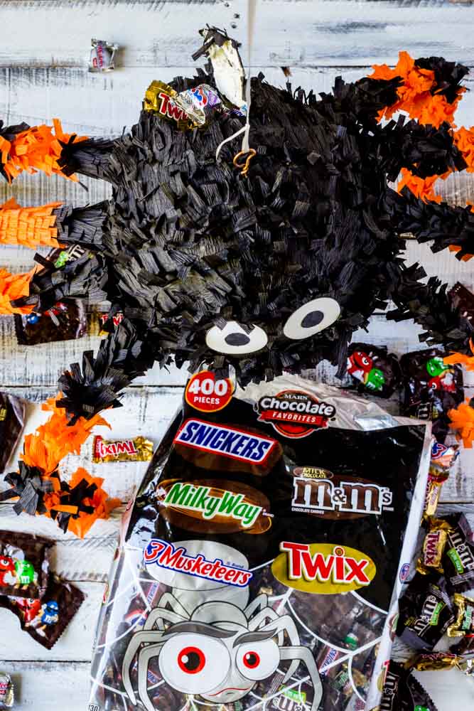 A giant bag of Halloween candy with individual packets spilling out.