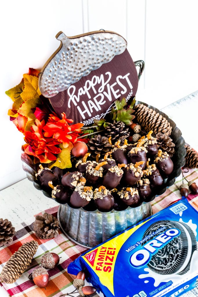 Metal cake stand filled with acorn-shaped Oreo balls.