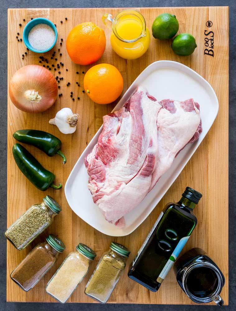 Ingredients for making pork carnitas laid out on a Boos Block cutting board.