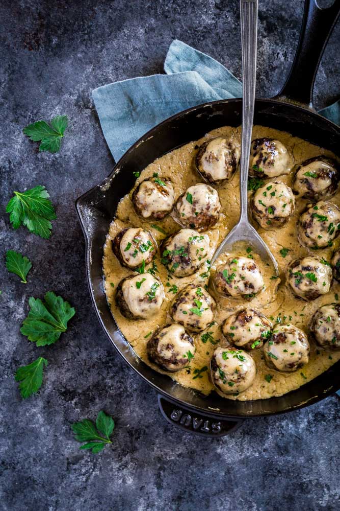 Swedish meatballs in a skillet with Swedish meatball gravy, garnished with Italian parsley.