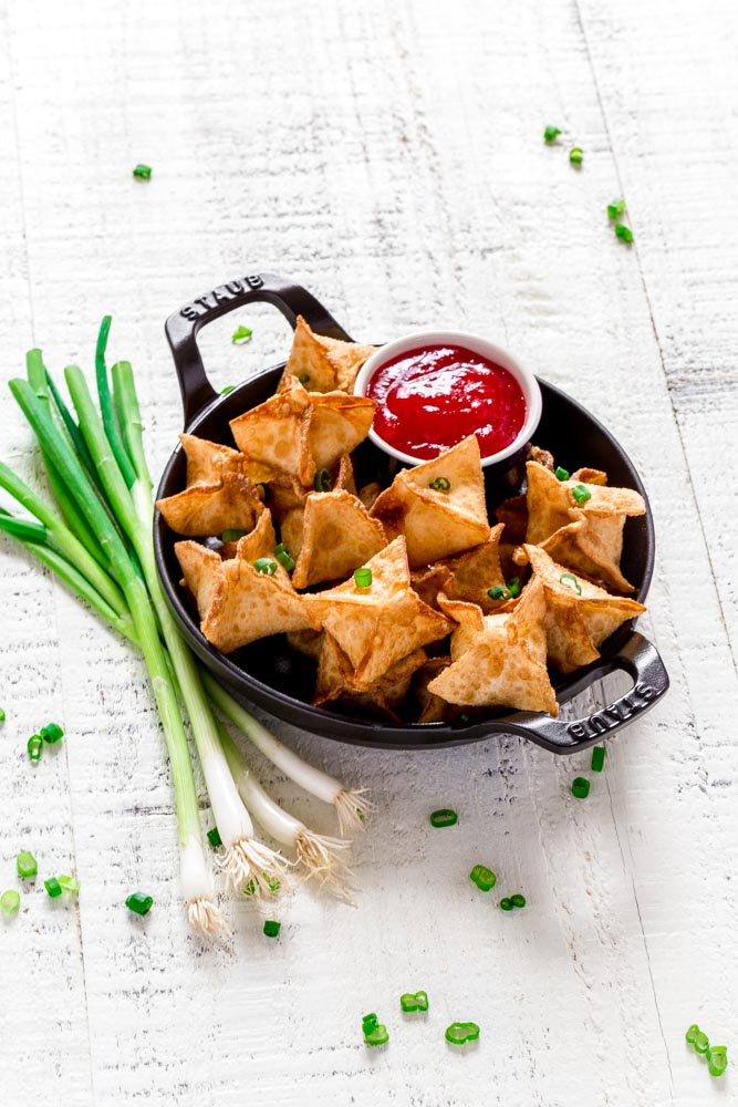 Fried cheese wontons garnished with green onion and served with sweet and sour dipping sauce.