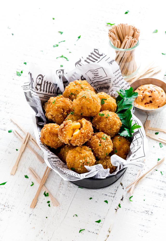 Mac and Cheese Bites sprinkled with parsley and served with bang bang sauce on the side.