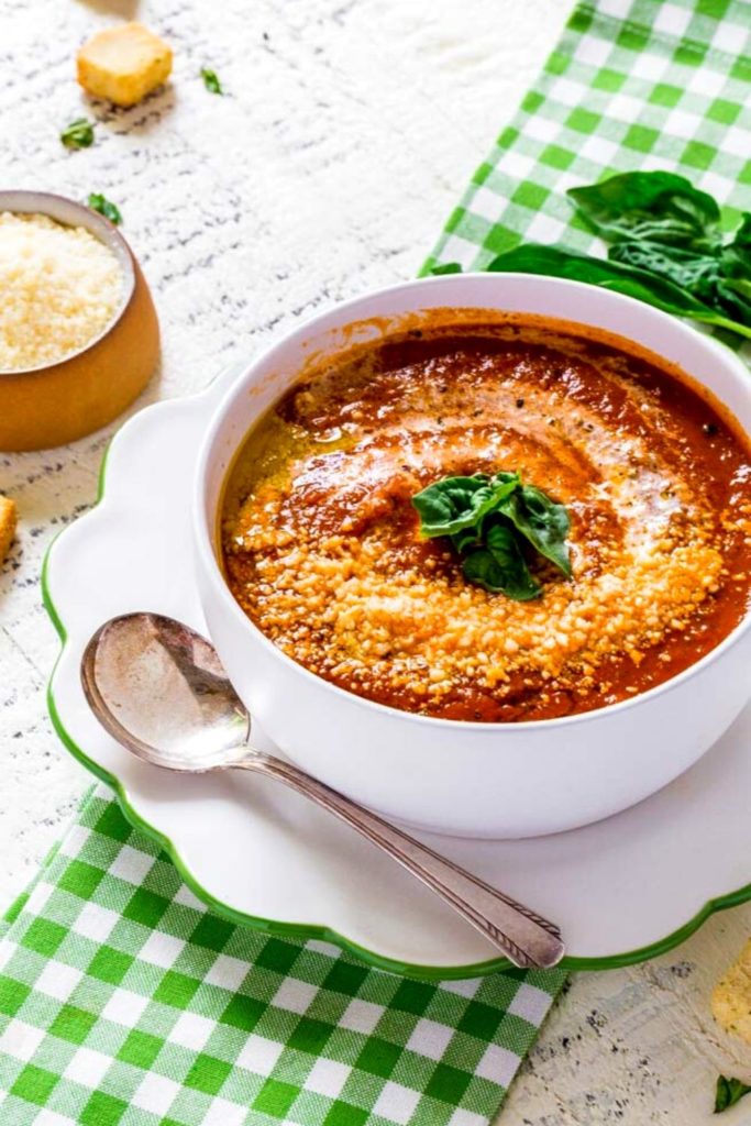 Best tomato basil soup served with a torn-basil garnish and grated parmesan.