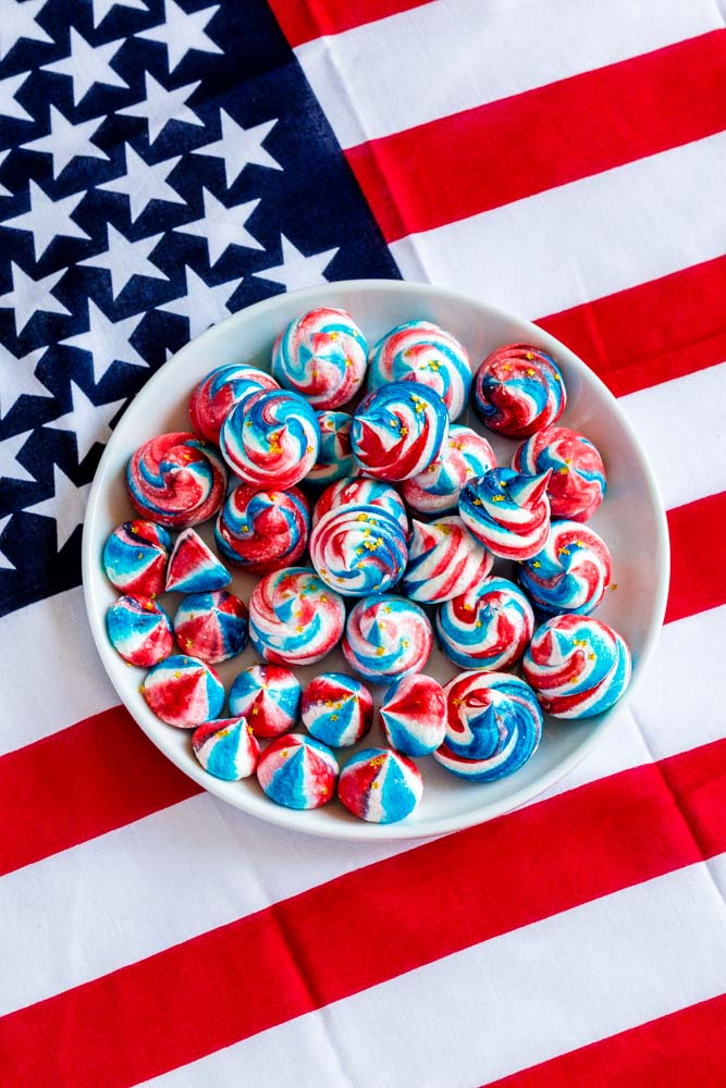 A plate of 4th of July meringue cookies on an American flag tablecloth.