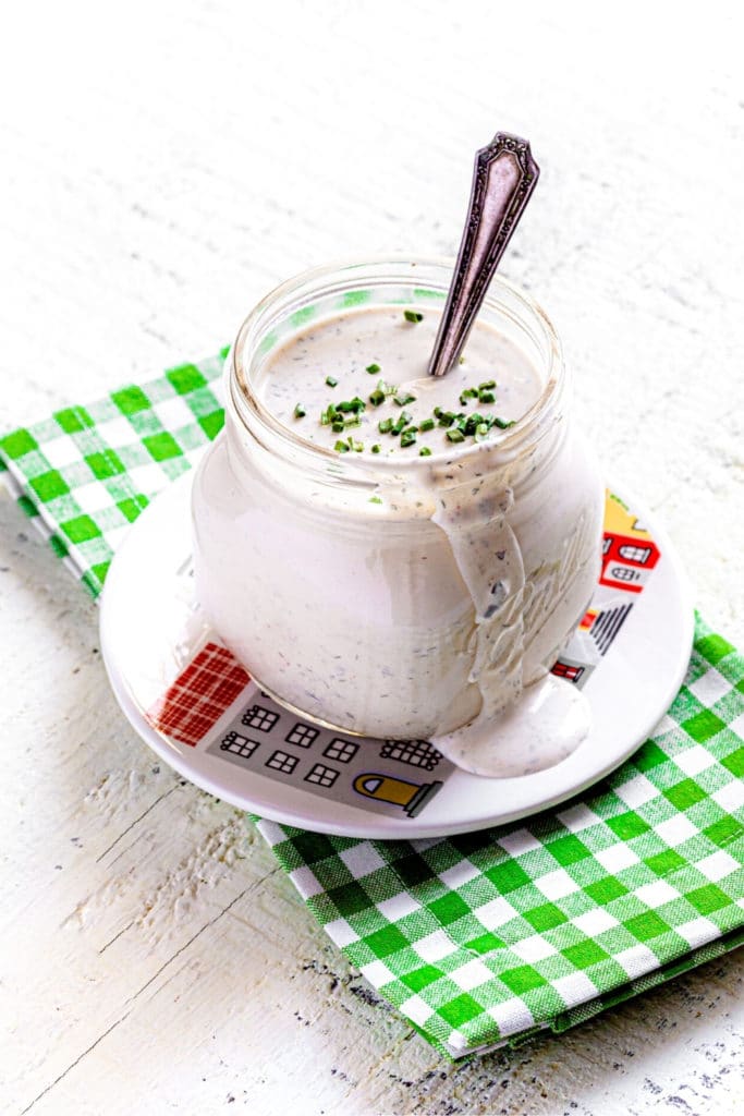 Homemade buttermilk ranch dressing in a glass mason jar with spoon.