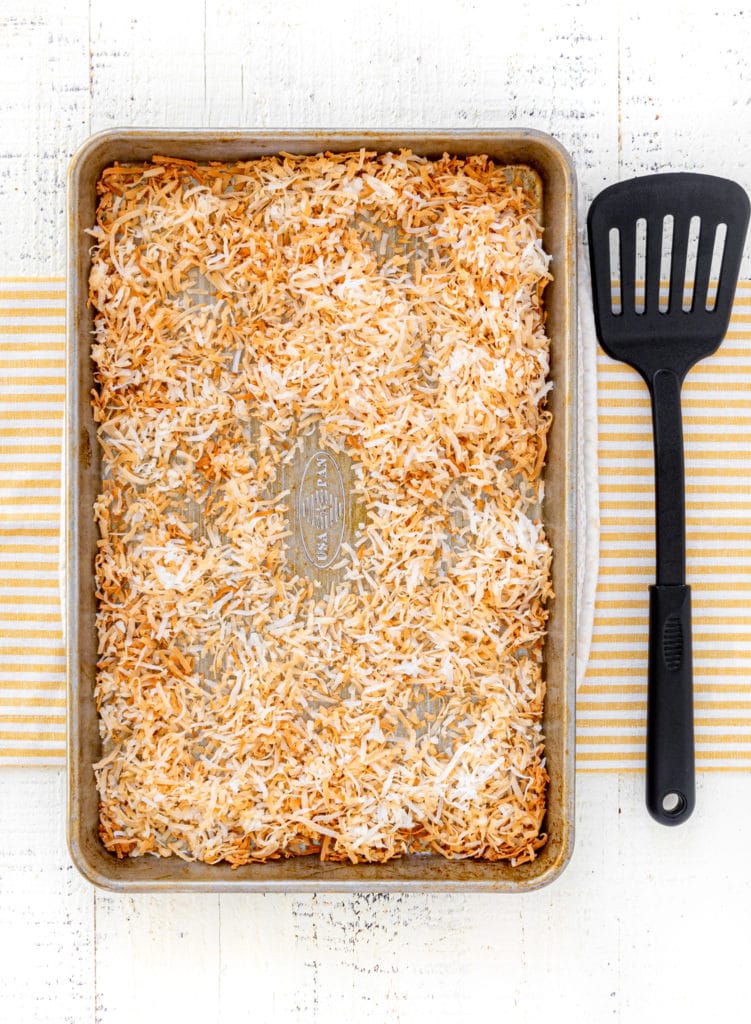 Toasted shredded coconut on a baking tray for topping mini robin's nest Easter cheesecakes.