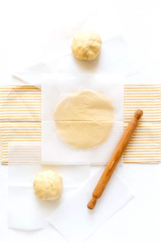 Prepping dough for cut-out sugar cookie recipe with a rolling pin.