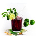 Ice cold glass of agua fresca. This hibiscus iced tea is garnished with mint and lime.