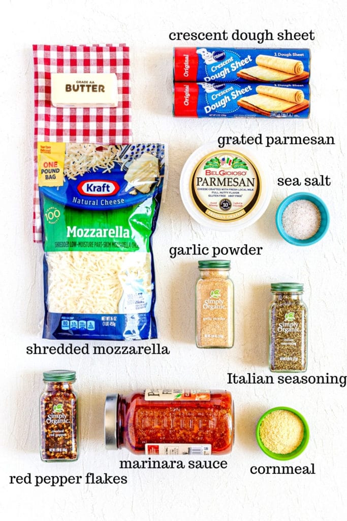Ingredients for cheesy breadsticks on a white tabletop.