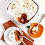 Sweet Potato Fluff Casserole in a white baking dish plus a serving with spoon and fork.