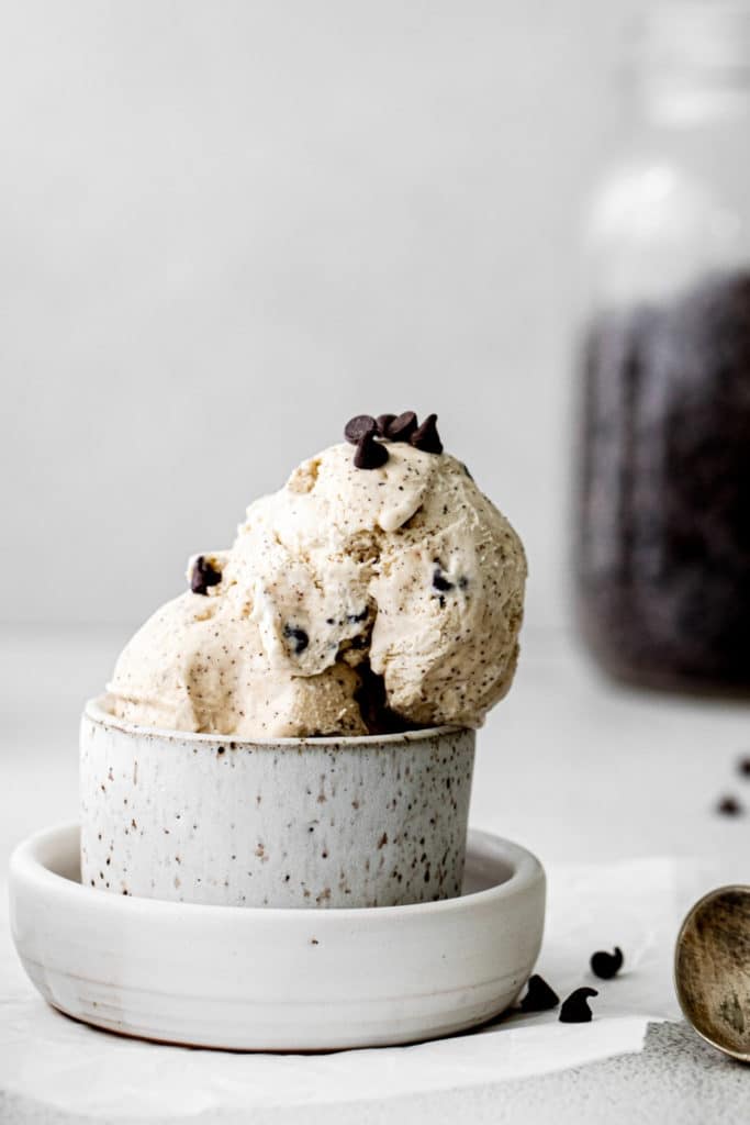 A single serving of homemade chocolate chip ice cream with metal spoon.