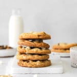 Stack of 5 white chocolate chip cookies on a white marble board.