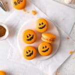 French Halloween Pumpkin Macarons with spooky Jack 'o Lantern faces.