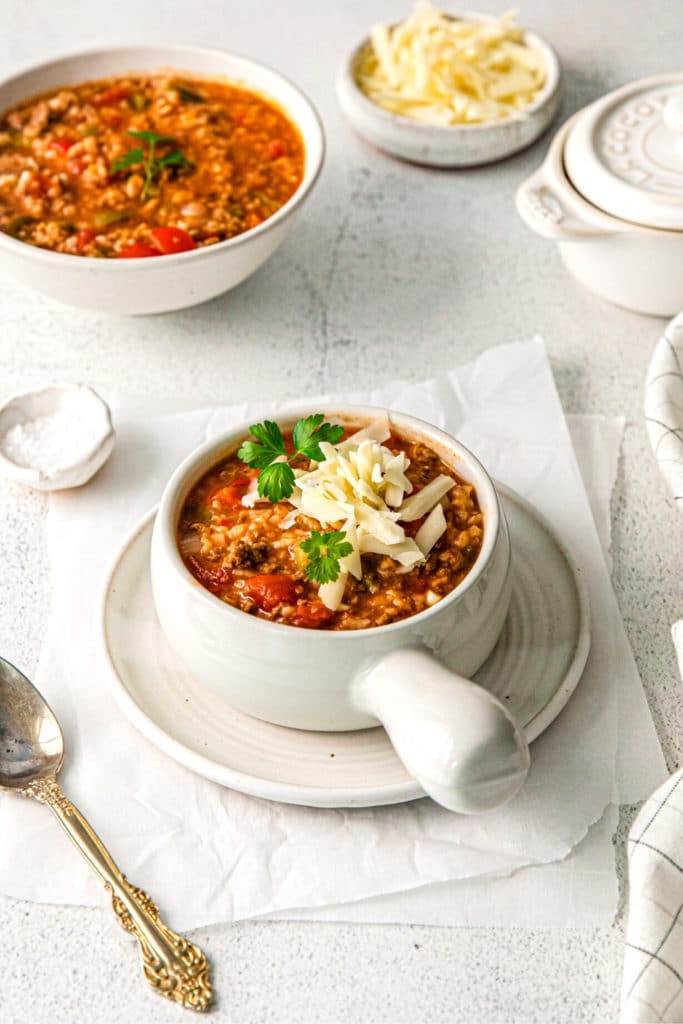 Serving of Instant Pot stuffed pepper soup with cheese. Served in a soup bowl with handle.