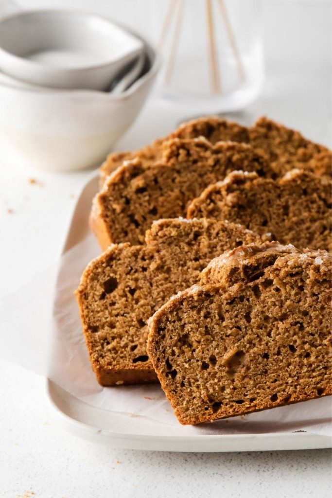 Five thick slices of homemade Starbucks Gingerbread Loaf on a small white serving tray.