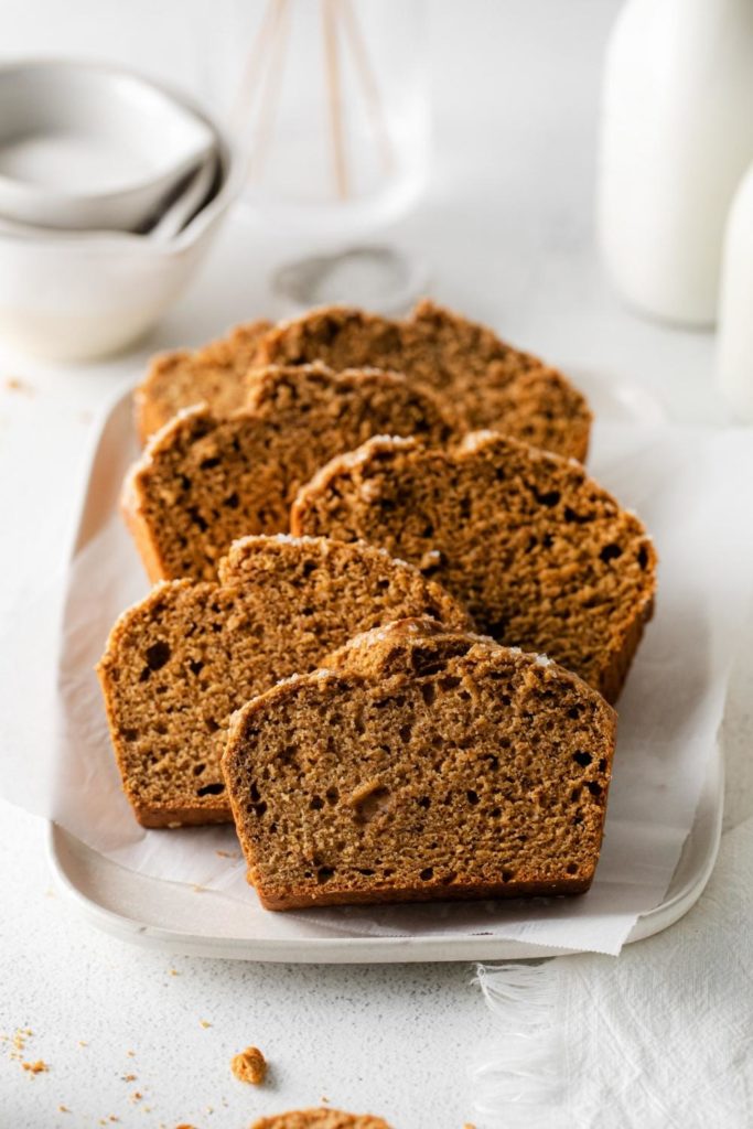 Starbucks Gingerbread Loaf made with vegan ingredients sliced and served on a white rectangular platter.
