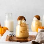Pumpkin mousse parfait with a dollop of whipped cream, a gingersnap cookie and cookie crumbs.