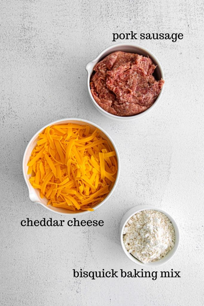 Three ingredients for sausage cheese balls: pork sausage, shredded cheddar cheese, Bisquick baking mix.