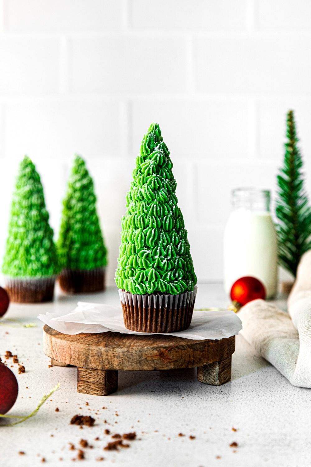 Christmas tree cupcakes on a holiday dessert table with milk.