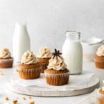 Gingerbread Christmas cupcakes on a white serving board with milk.