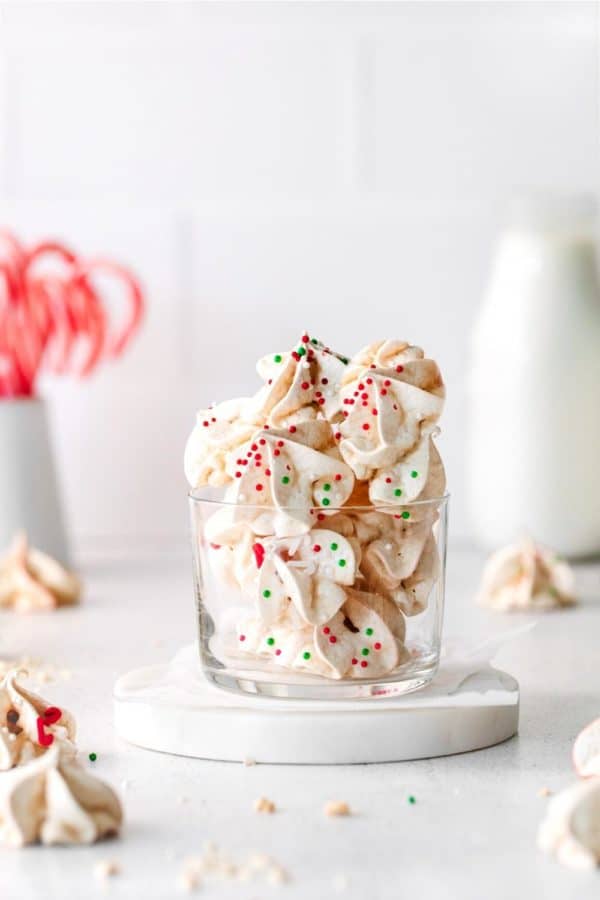 Clear-glass dish with peppermint meringues set on a Christmas dessert table.