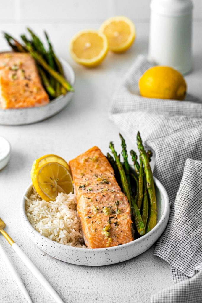 Sheet pan salmon and asparagus served with fresh slices of lemon.
