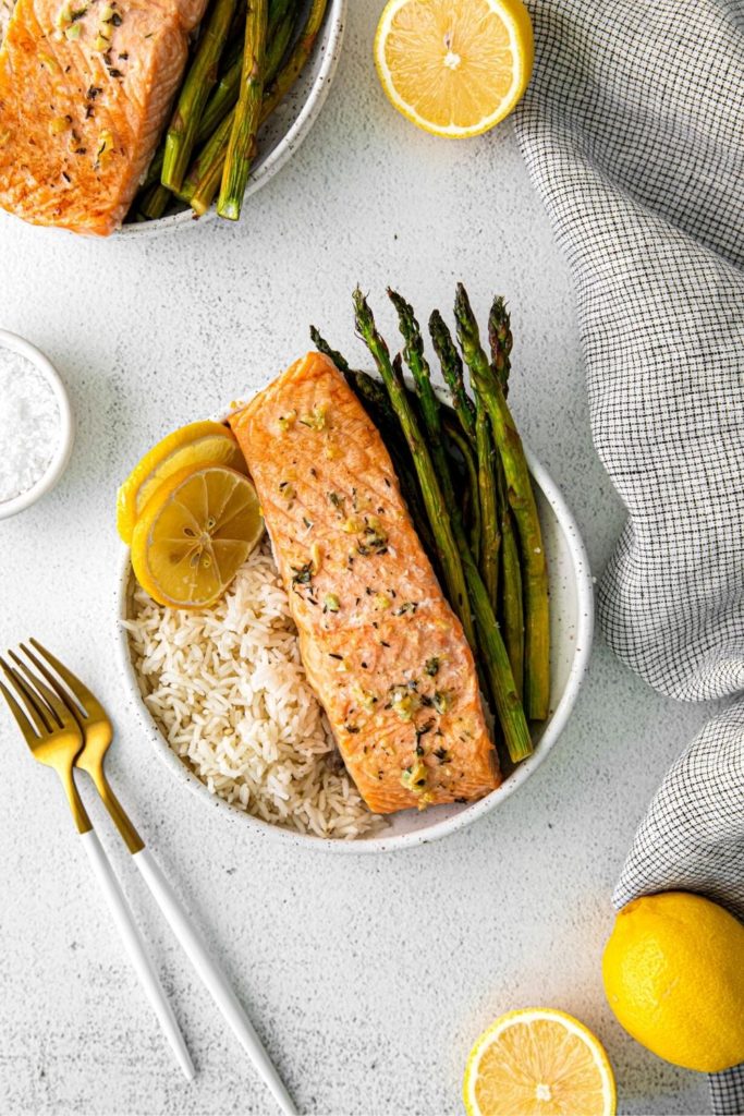 Individual serving of lemon garlic-butter salmon with asparagus on a dinner table.